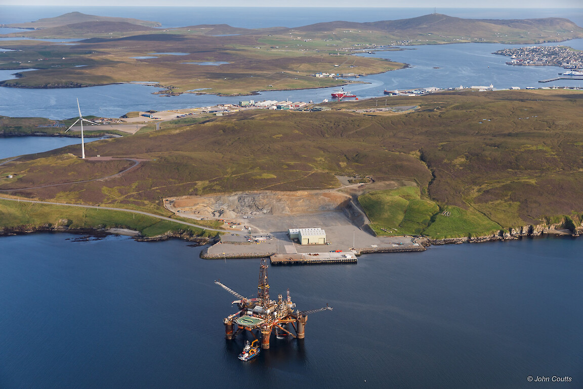 The extended quay at Dales Voe, Lerwick Harbour, provides the offshore industry with the strongest quay in the UK, at 60 tonnes per square metre. The Buchan Alpha floating production unit, which recently arrived for decommissioning, is seen in the foreground. Credit: John Coutts.