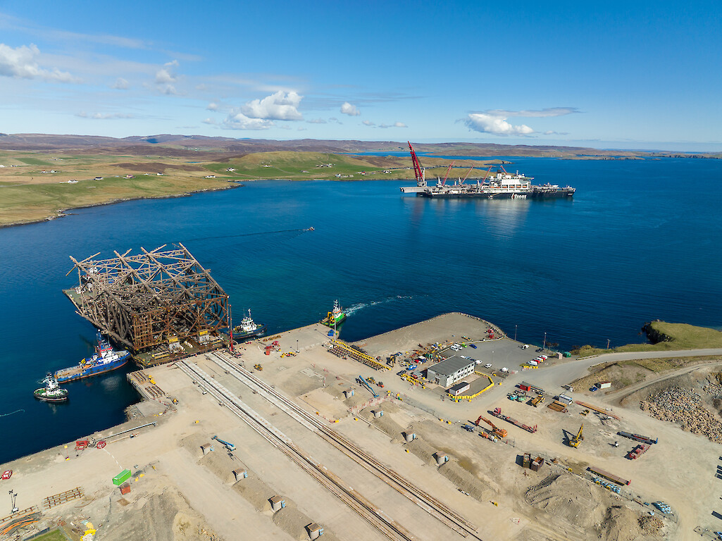 "Iron Lady" barge alongside Dales Voe quay with jacket structure for load-in. "Pioneering Spirit" in background. © Rory Gillies/Shetland Flyer Aerial Media.